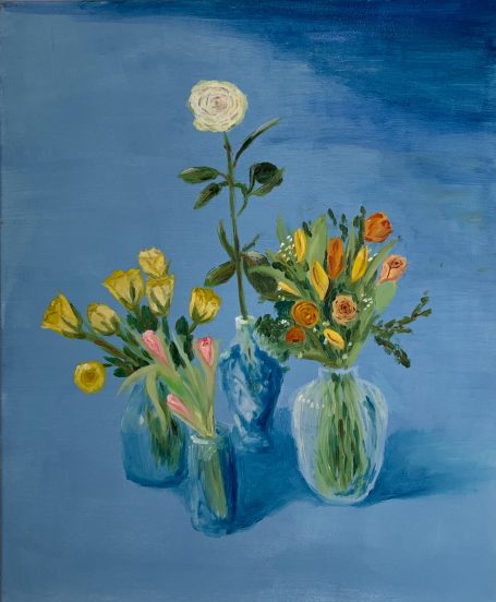 3 Vasen mit unterschiedlichen Tulpen und Rosen vor blauen Hintergrund